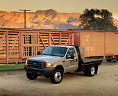 AUT 14 RK0285 03
1999 Ford F550 Flatbed Champagne 3/4 Front View On Dirt By Train And Mountains