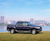 AUT 14 RK0348 03
2001 Ford Explorer Sport Trac Blue 3/4 Front View On Grass By Water Buildings In Background Blue Sky