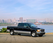 AUT 14 RK0358 03
2000 Ford SD F-350 Crew Cab Black And Silver 3/4 Front View On Pavement By Water Buildings In Background
