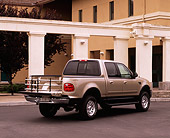 AUT 14 RK0406 02
2001 Ford F150 Super Crew 4x4 Pickup Truck Gold 3/4 Rear View On Pavement By Building