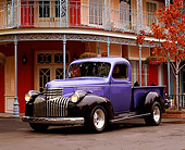 AUT 14 RK0453 01
1941 Chevy 1/2 Ton Pick Up Truck Black And Purple 3/4 Front View On Pavement By Building
