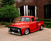 AUT 14 RK0519 04
1955 Ford F-100 Custom Pick Up Truck Red 3/4 Front View On Pavement By Building And Trees