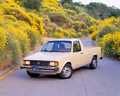 AUT 14 RK0523 06
1982 VW Rabbit Pick Up Truck Beige 3/4 Front View On Pavement By Yellow Flower Bushes