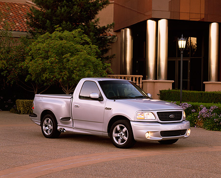 01 Ford Lightning F 150 Silver 3 4 Side View On Pavement Building And Trees Kimballstock