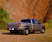 AUT 14 RK0668 03
2002 GMC Sierra Denali AWD 4 Door Pewter Low 3/4 Rear View On Dirt Against Rock