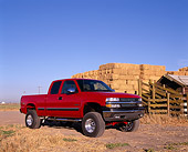 AUT 14 RK0771 02
2002 Chevy 1500 Z71 4WD Pick Up Truck Red 3/4 Side View By Hay Stacks Blue Sky