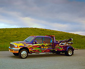 AUT 14 RK0980 01
1999 Ford F550 Tow Truck Custom Graphic Paint 3/4 Side View On Pavement By Grass Hill Filtered