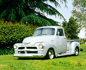 AUT 14 RK1054 05
1954 Chevy 1/2 Ton 3100 Custom Silver 3/4 Front View On Grass By Trees