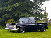 AUT 14 RK1160 01
1987 Chevrolet Silverado Pick Up Truck Black 3/4 Side View On Grass By Trees