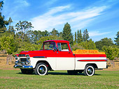 AUT 14 RK1388 01
1959 Chevrolet Apache Deluxe Pickup Truck Red And White 3/4 Front View On Grass By Trees