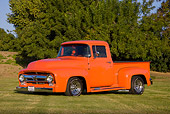 AUT 14 RK1412 01
1956 Ford F-100 Pickup Truck Orange 3/4 Front View On Grass By Trees