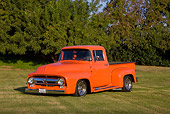 AUT 14 RK1413 01
1956 Ford F-100 Pickup Truck Orange 3/4 Front View On Grass By Trees
