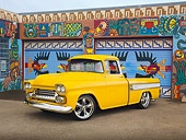 AUT 14 RK1517 01
1958 Chevrolet Cameo Pickup Truck Yellow 3/4 Front View On Pavement By Colorful Building
