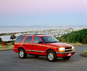 AUT 15 RK0312 02
2000 Chevrolet Blazer Red Side 3/4 View On Pavement Harbor Background Filtered