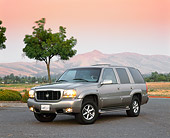 AUT 15 RK0501 05
2000 Cadillac Escalade Champagne 3/4 Front View On Pavement Mountains Pink Sky