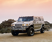 AUT 15 RK0731 03
2003 H2 Hummer Canepa Custom Matte Pewter Low 3/4 Front View On Sand By Rocks Filtered