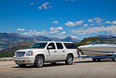 AUT 15 RK1230 01
2011 Yukon Denali White With 226 Cobalt Boat 3/4 Front View On Pavement By Mountains