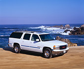 AUT 15 RK0287 13
2000 GMC Yukon XL 1/2 Ton  White 3/4 Side View On Sand By Ocean Blue Sky
