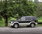 AUT 15 RK0331 01
2000 Isuzu Trooper Green 3/4 Front View By Trees