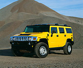 AUT 15 RK0616 03
2003 GM H2 Hummer Yellow 3/4 Front View By Pile Of Gravel Blue Sky