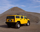 AUT 15 RK0624 03
2003 Hummer H2 Yellow 3/4 Rear View By Pile Of Gravel Blue Sky