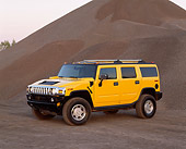 AUT 15 RK0629 02
2003 Hummer H2 Yellow 3/4 Front View By Pile Of Gravel At Dusk