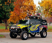 AUT 15 RK0856 01
2002 H2 XTC Hummer Custom Graphics 3/4 Side View On Pavement By Fall Trees