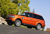 AUT 15 RK0898 01
2006 Land Rover Range Rover Sport Supercharged Orange 3/4 Side View On Pavement By Trees