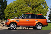 AUT 15 RK0899 01
2006 Land Rover Range Rover Sport Supercharged Orange Profile On Pavement By Tree