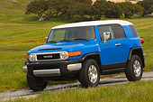 AUT 15 RK0965 01
2007 Toyota FJ Cruiser Blue And White 3/4 Front View On Pavement By Grass Hills
