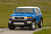 AUT 15 RK0966 01
2007 Toyota FJ Cruiser Blue And White 3/4 Front View On Pavement By Grass Hills
