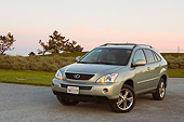 AUT 15 RK0989 01
2006 Lexus RX400 Hybrid Light Green 3/4 Front View On Pavement By Grass Hills At Dusk