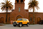 AUT 15 RK1010 01
2007 Toyota FJ Cruiser Yellow And White Low 3/4 Front View On Pavement By Building And Palm Trees