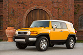 AUT 15 RK1011 01
2007 Toyota FJ Cruiser Yellow And White Low 3/4 Front View On Pavement By Building