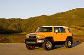 AUT 15 RK1012 01
2007 Toyota FJ Cruiser Yellow And White Low 3/4 Front View On Pavement By Grass Hills