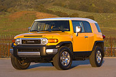 AUT 15 RK1013 01
2007 Toyota FJ Cruiser Yellow And White Low 3/4 Front View On Pavement By Grass Hills