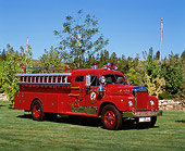 AUT 16 RK0051 03
1959 Mack B85F Firetruck Red Front 3/4 View On Grass By Trees Blue Sky