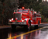 AUT 16 RK0098 14
1961 Oshkosh 1250 GPM Pumper Front 3/4 View On Wet Road By Trees