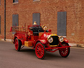 AUT 16 RK0135 01
1909 Kissel Hose And Chemical Firetruck Red 3/4 Front View On Pavement By Brick Building