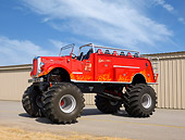 AUT 16 RK0167 01
1947 Mack Pumper Fire Engine Monster Truck Red 3/4 Front View On Pavement By Building