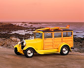 AUT 18 RK0035 04
1929 Ford Woody Yellow With Surfboard 3/4 Side View On Sand By Ocean