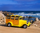 AUT 18 RK0037 04
1929 Ford Woody Yellow With Surfboard 3/4 Front View On Sand By Ocean