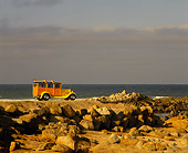 AUT 18 RK0043 02
1929 Ford Woody Yellow With Surfboard 3/4 Rear View By Rocks And Ocean Filtered