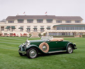 AUT 18 RK0055 03
1929 645 Packard Roadster Green 3/4 Front View On Grass Building Background