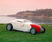 AUT 19 RK0424 10
1934 Ford So-Cal Special Coupe 3/4 Front View Red And White On Grass By Water Red Sky Pebble Beach