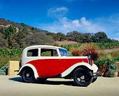 AUT 19 RK0592 02
1935 Morris Eight Red And White Low Profile Shot On Pavement By Hills And Trees