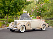 AUT 19 RK0844 01
1935 Packard Convertible 1201 Cream 3/4 Front View On Pavement By Trees And House