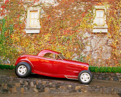 AUT 19 RK0138 03
1932 Ford Roadster Red Hot Rod Profile View On Ramp By Building