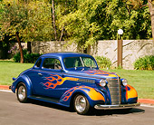 AUT 19 RK0229 04
1938 Chevrolet Coupe Blue With Flames 3/4 Front View By Stone Wall Trees