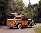 AUT 19 RK0327 01
1936 Dodge Woody Westchester Suburban With Surfboard 3/4 Rear View By Trees